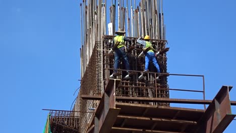 Trabajadores-De-La-Construcción-Que-Trabajan-En-Altura-Fabricando-Barras-De-Refuerzo-De-Acero-En-El-Sitio-De-Construcción