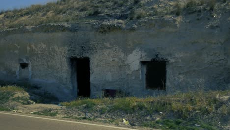 Una-Toma-De-Dos-Casas-Excavadas-En-La-Roca-Cerca-De-Una-Carretera