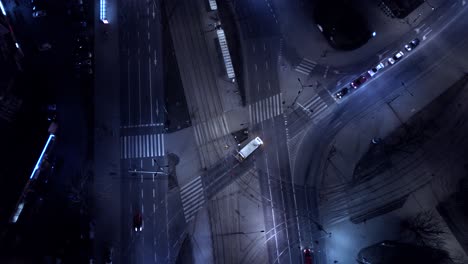 Aerial-night-vertical-view-Traffic-cars-on-the-intersection-and-street-lights-and-illuminated-streets-in-a-modern-city