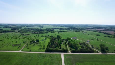 Aerial-fly-into-flat-grassland-dotted-with-trees-around-Flint-Hills,-Kansas-Missouri