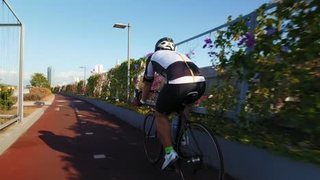A-look-from-behind-of-a-cyclist-training-in-a-sunny-day