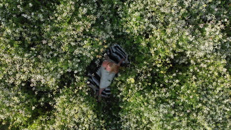 Aerial-Spin-of-Young-Woman-Lying-in-Flowers
