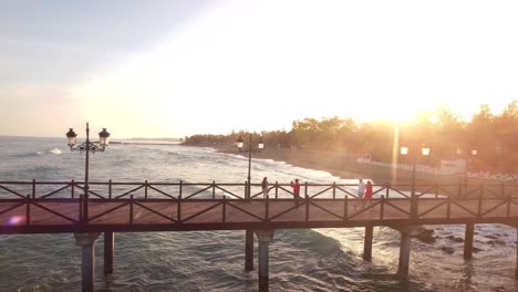 sunset-from-drone-beautiful-view-of-pier-and-couples-walking-on-it