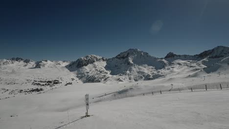 Familias-Esquiando-Con-Una-Hermosa-Vista-Aérea-De-La-Montaña-Cubierta-De-Nieve-En-Un-Día-Soleado