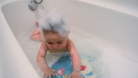 baby-having-foamy-bath---cute-six-months-old-baby-on-his-tummy-in-the-bathtub