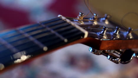A-big-close-up-of-a-bass-guitar-Strings-with-its-base,-light-reflections-and-focus-shifting-on-the-guitar