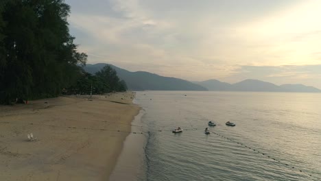 A-slowmo-drone-shot-over-a-deserted-beach-in-Penang,-Malaysia