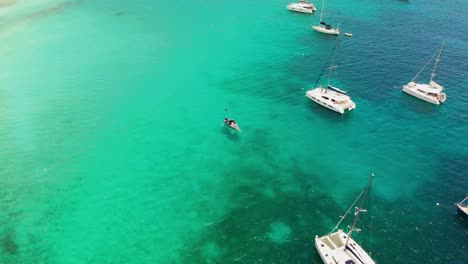Birds-eye-view-of-yachts-and-speed-boat-anchored-at-the-crystal-clear-waters-of-Tobago-Cays