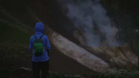 Isländische-Landschaft,-Geothermischer-Heißer-Dampfrauch,-Eine-Person-Beobachtet-Den-Aufsteigenden-Rauch,-Kamera-Nach-Oben-Geneigt,-Dunkle-Und-Stimmungsvolle-Abendatmosphäre