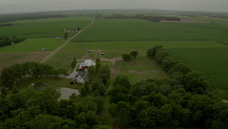 Aerial-over-farmland-with-barn-and-farmhouse-and-horses
