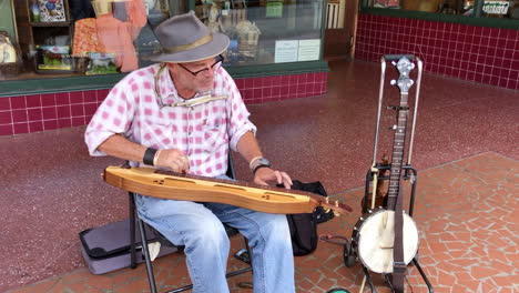 Man-street-performer-playing-music-on-sidewalk