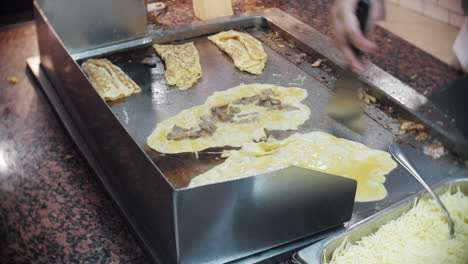 El-Chef-Voltea-Tortillas-De-Champiñones-Y-Queso-En-Una-Parrilla-Caliente-En-Un-Restaurante