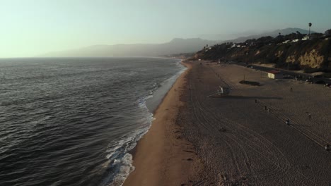 An-Aerial-Shot-Looking-Out-Over-a-Beach-Near-Point-Dume-Cliff-in-Malibu-in-California-in-the-Evening-as-the-Sunsets