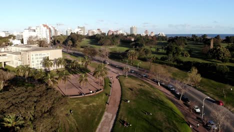 Luftaufnahme-Des-Parks-Mit-Gebäuden-Und-Dem-Meer-Im-Hintergrund-In-Montevideo,-Uruguay