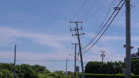 Ekectric-pylons-by-the-road,-filmed-from-a-moving-car-in-Montauk,-New-York---180-fps-slow-motion