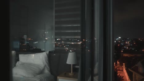 Nachtblick-Auf-Das-Schlafzimmer-Der-Wohnung-Vom-Balkon-Aus-Durch-Panoramafenster-Mit-Reflexionen-Der-Nächtlichen-Stadtlichter