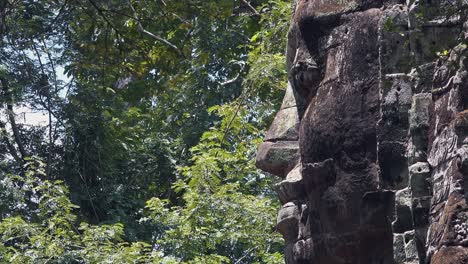 Zoom-Out-From-Large-Stone-Face-In-The-Jungles-Surrounding-Angkor-Wat
