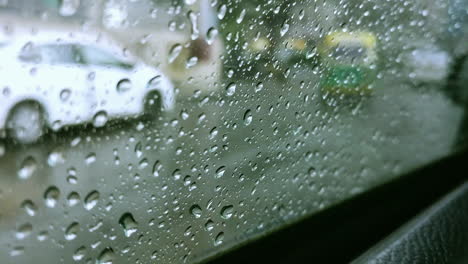 Ein-Schnell-Fahrendes-Auto-Im-Verkehr,-Dessen-Fenster-Mit-Wassertropfen-Bedeckt-Ist,-Konzentriert-Sich-Bei-Starkem-Regen