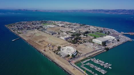 4k-aerial-drone-view-of-treasure-island-san-francisco-bay-area-surrounded-by-turquoise-blue-ocean-sea-water-waves-camera-move-forward