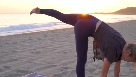 Female-performing-yoga-moves-on-a-beach-at-sunset