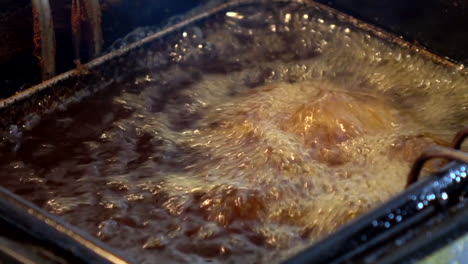 Close-Up-of-cooked-chicken-being-boiled-in-hot-cooking-oil