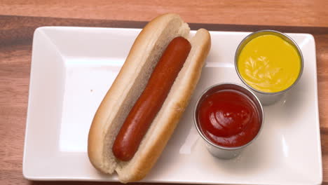 Draufsicht-Auf-Eine-Hand,-Die-Einen-Hotdog-Von-Einem-Teller-Nimmt