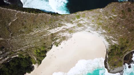 Drone-Shot-flying-over-the-ridge-line-separating-KelingKing-beach-and-some-rugged-cliffs-of-Nuse-Penida