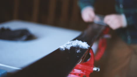 Slow-motion-shot-of-a-person-scraping-wax-off-of-skis