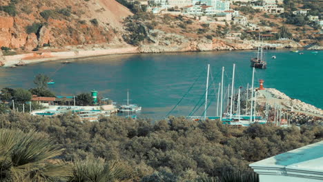 Time-lapse-of-busy-Kalkan-port-in-Turkey,-shot-from-the-mountainside-as-boats-arrive-and-depart-taking-tourists-on-boat-trips