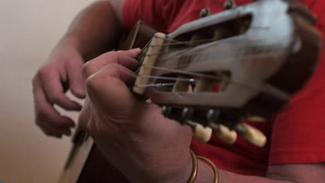 A-musician-plucking-and-strumming-on-a-Spanish-guitar-Close-up