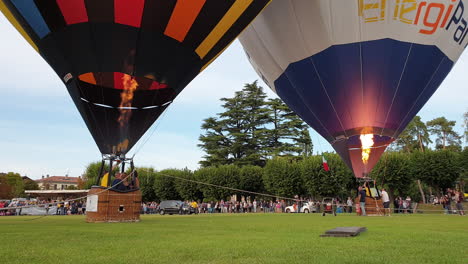 two-hot-air-balloons-ready-to-fly,-low-angle-still-two-shot