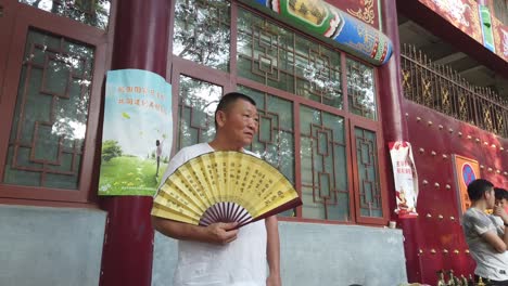 Xian,-China---Julio-De-2019:-Hombre-Mayor-Vendiendo-Abanicos-De-Papel-De-Colores-En-Un-Día-Caluroso-En-La-Calle-En-El-Barrio-Musulmán