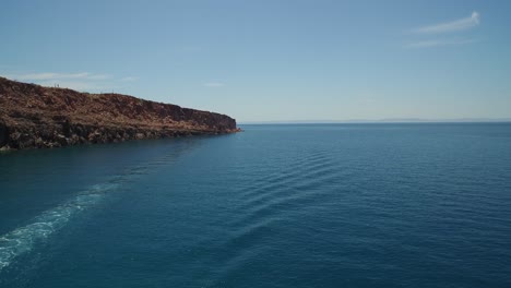 Aerial-shot-of-a-boat-passing-by-in-Espiritu-Santo-Island,-Archipielago-Espiritu-Santo-National-Park,-Baja-California-Sur