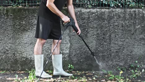 A-man-who-cleans-concrete-wall-using-a-high-pressure-washer