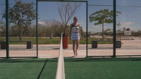 Beautiful-young-woman-entering-paddle-tennis-court-slow-motion