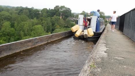 British-tourist-steering-canal-boats-on-Pontcysyllte-Aqueduct-Welsh-countryside-waterway