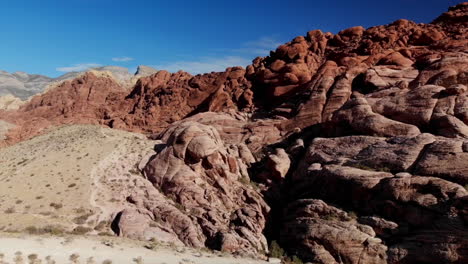 Bird's-eye-view-of-red-sandstone-mountains-from-drone,-Red-Rock-Canyon-Park-near-Las-Vegas,-Nevada