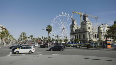 Ferris-wheel-and-Barcelona-busy-city-street,-Catalonia,-Spain
