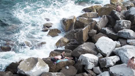 Tourists-lying-on-the-rocks-of-coast-of-Riomaggiore