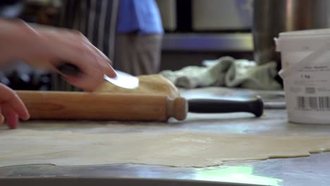 A-patissier-works-fast-to-roll-out-pastry-thinly-and-cuts-off-scraps-to-use-a-nice-straight-sheet