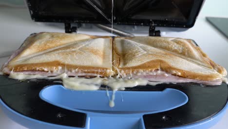 Nahaufnahme-Mit-Den-Händen-Eines-Mannes,-Der-Den-Sandwichmaker-öffnet-Und-Zwei-Sandwiches-Zubereitet
