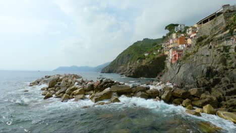 Touristen,-Die-Auf-Den-Felsen-Der-Küste-Von-Riomaggiore-Liegen