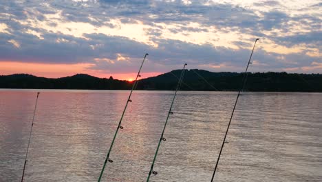 Sonnenuntergang-über-Einem-See-Mit-Angelruten-Im-Vordergrund