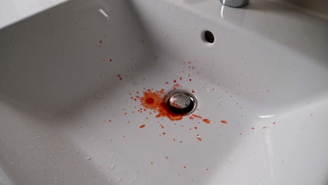Slow-motion-shot-of-the-fresh-blood-dripping-into-the-bathroom-sink