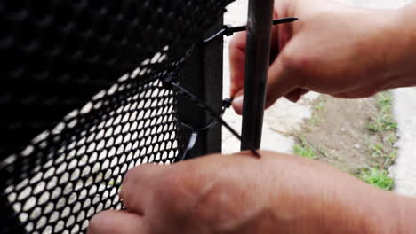 Plastic-net-being-fixed-to-a-gate