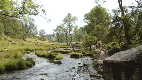 Time-Lapse-of-walkers-trekking-path-alongside-stream,-Yorkshire-Dales