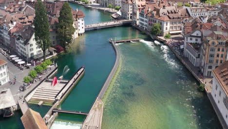 Aerial-of-canal-and-revealing-the-city-and-a-beautiful-church-in-downtown-Luzern-,-Switzerland