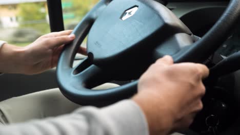 Close-up-shot-on-a-white-man's-hands-driving-a-Renault-van-steering-wheel