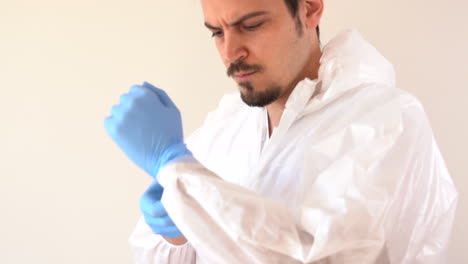 Doctor-in-PPE-suit-isolating-gloves-and-suit-to-start-his-service