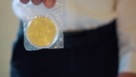 Geschäftsmann-Im-Hintergrund,-Der-Im-Vordergrund-Goldene-Bitcoins-In-Einer-Plastiktüte-Hält